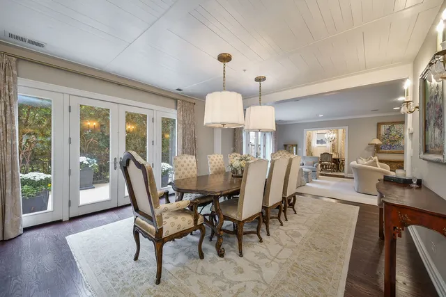a dining room with furniture a chandelier and wooden floor