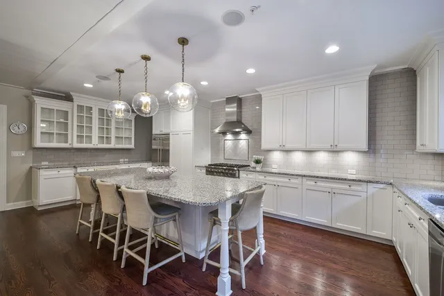 a kitchen with a dining table chairs wooden floor and appliances