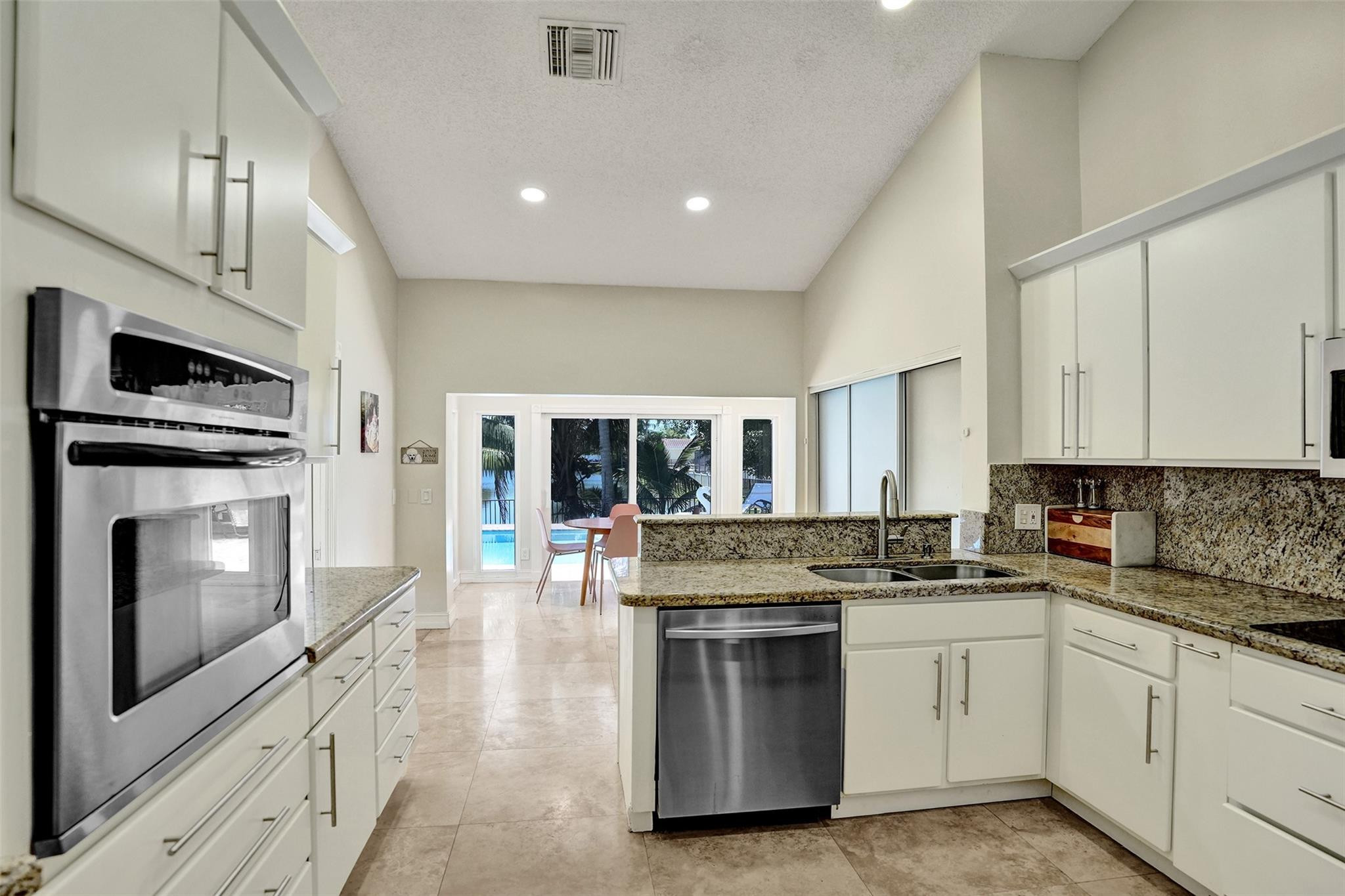 10130 Northwest 13th Street Plantation, FL 33322 - Photo 3 of 23 a kitchen with granite countertop white cabinets and stainless steel appliances