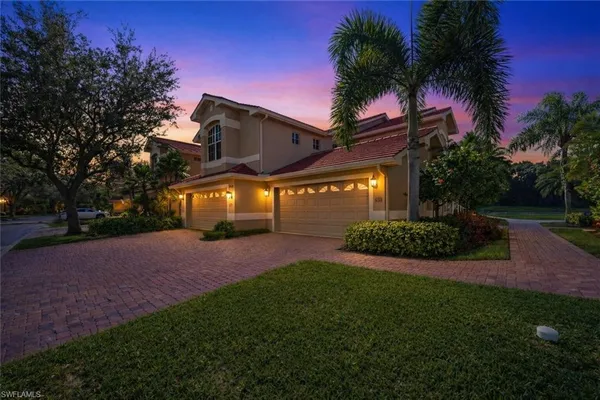a view of a house with a yard and palm tree