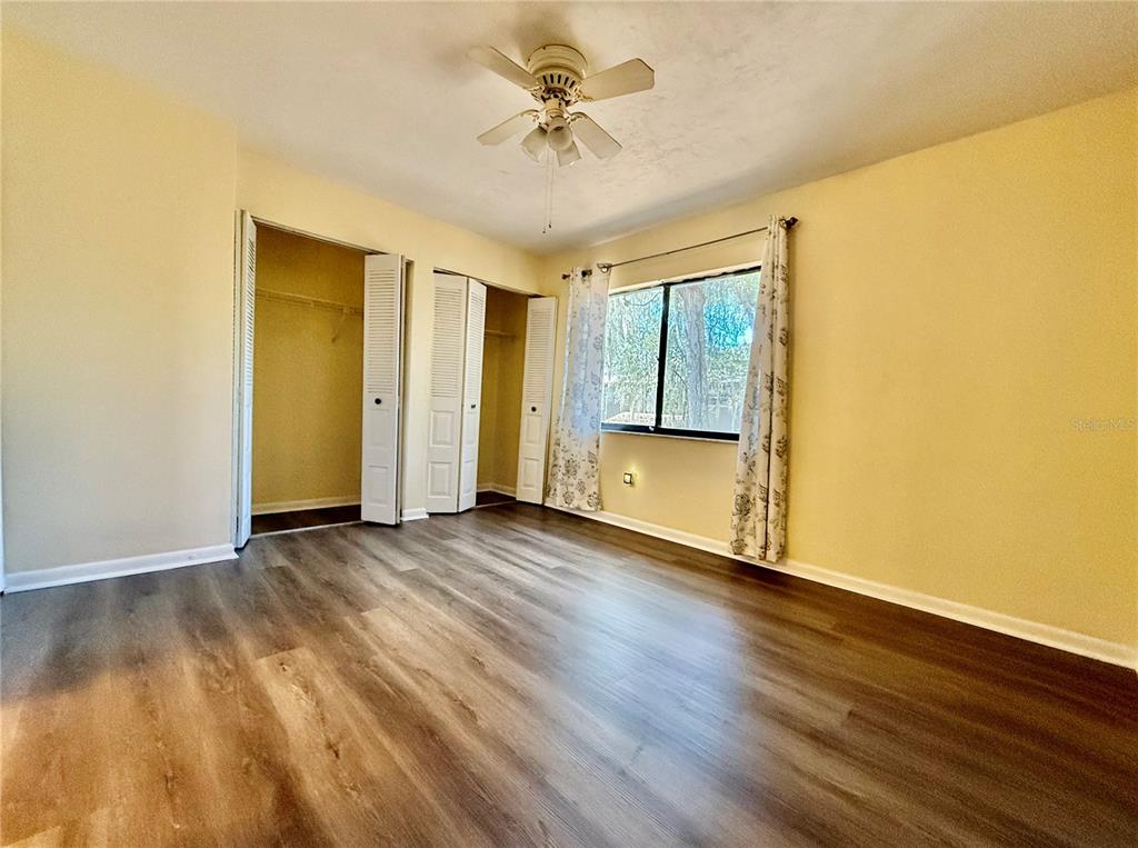 2735 Southwest 35th Place, Unit 1604 Gainesville, FL 32608 - Photo 18 of 25 an empty room with wooden floor and a ceiling fan