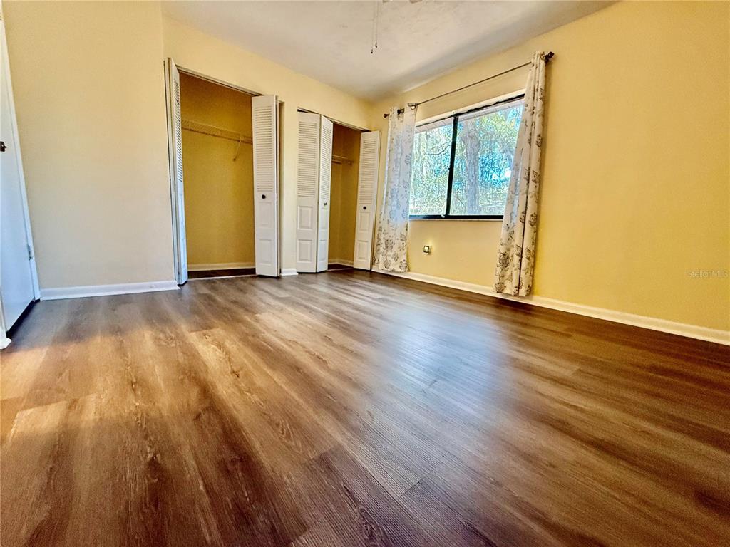 2735 Southwest 35th Place, Unit 1604 Gainesville, FL 32608 - Photo 19 of 25 an empty room with wooden floor and cabinet
