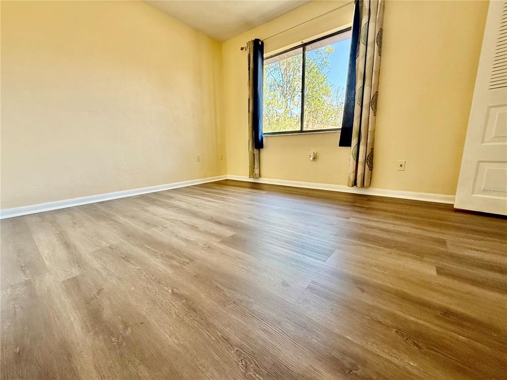 2735 Southwest 35th Place, Unit 1604 Gainesville, FL 32608 - Photo 23 of 25 a view of an empty room with wooden floor and a window