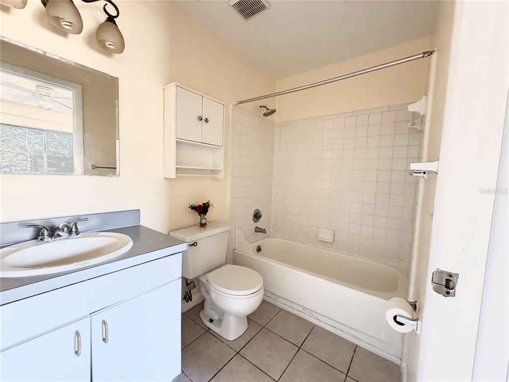 2735 Southwest 35th Place, Unit 1604 Gainesville, FL 32608 - Photo 24 of 25 a bathroom with a granite countertop sink a toilet and shower