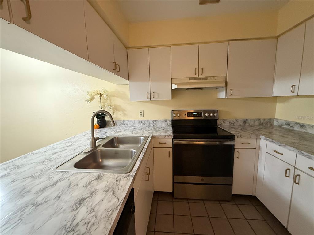 2735 Southwest 35th Place, Unit 1604 Gainesville, FL 32608 - Photo 5 of 25 a kitchen with a sink stove and cabinets
