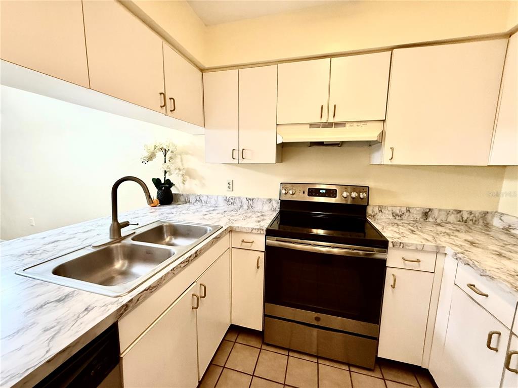 2735 Southwest 35th Place, Unit 1604 Gainesville, FL 32608 - Photo 6 of 25 a kitchen with stainless steel appliances granite countertop a sink stove and cabinets