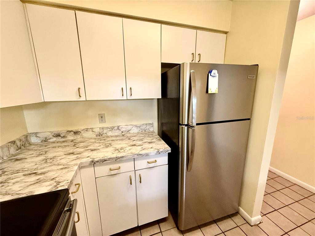 2735 Southwest 35th Place, Unit 1604 Gainesville, FL 32608 - Photo 9 of 25 a kitchen with a refrigerator and a stove