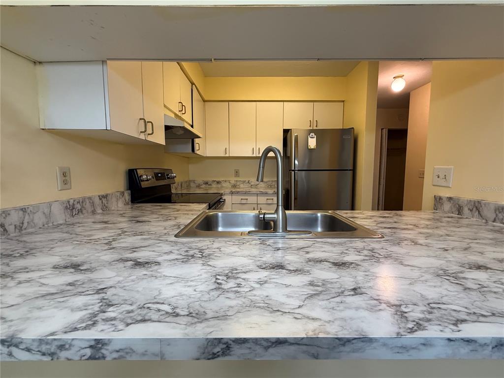2735 Southwest 35th Place, Unit 1604 Gainesville, FL 32608 - Photo 10 of 25 a kitchen with kitchen island a sink stove and refrigerator
