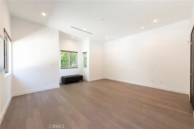 an empty room with wooden floor and a window