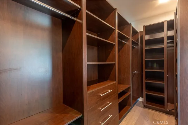 a view of walk in closet with empty racks