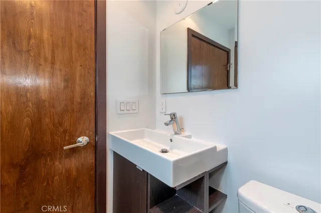 a bathroom with a toilet a sink and mirror