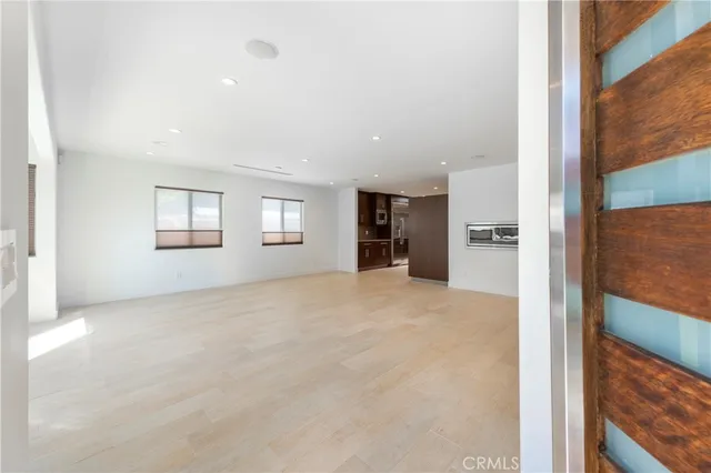 a view of empty room with a window and a kitchen