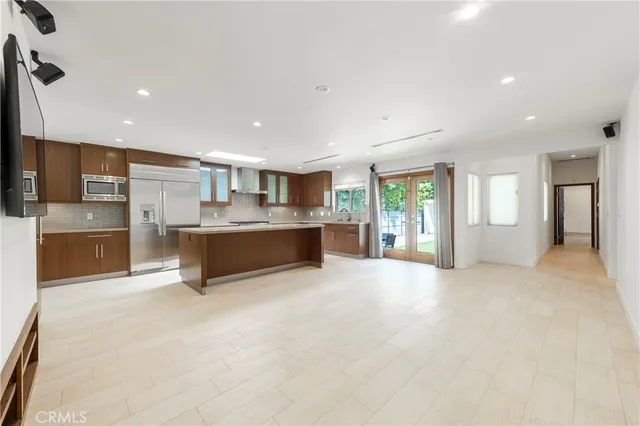 a large kitchen with stainless steel appliances granite countertop a large counter top a stove and a refrigerator with cabinets