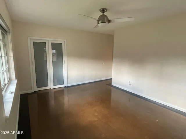 an empty room with a wooden door and windows