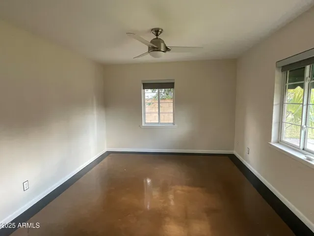 an empty room with a window and a ceiling fan