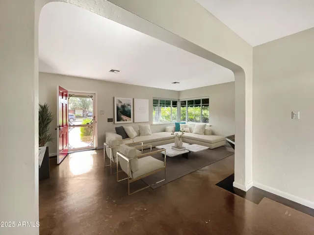 a living room with fireplace furniture and a large window