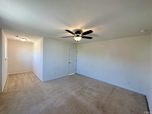 an empty room with a ceiling fan and wooden floor