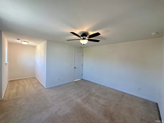 an empty room with a ceiling fan and wooden floor