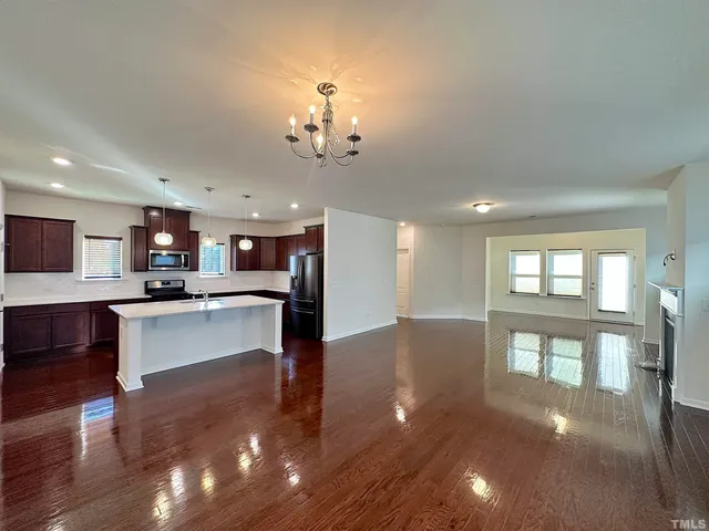 a view of a living room and kitchen with stainless steel appliances