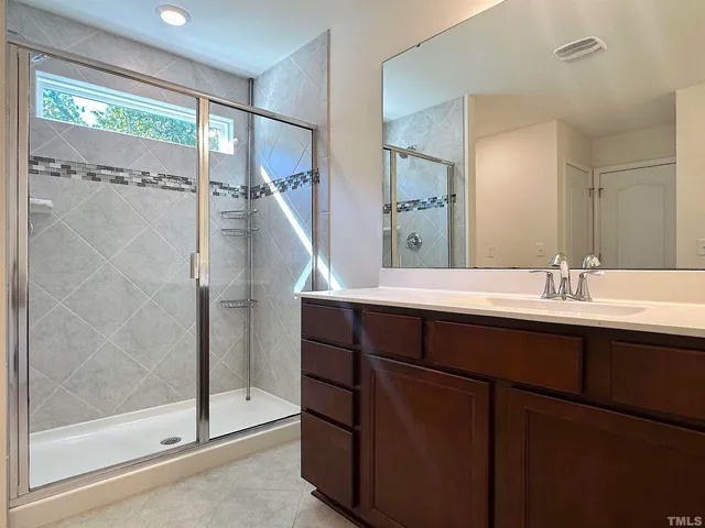 a bathroom with a double vanity sink mirror and shower