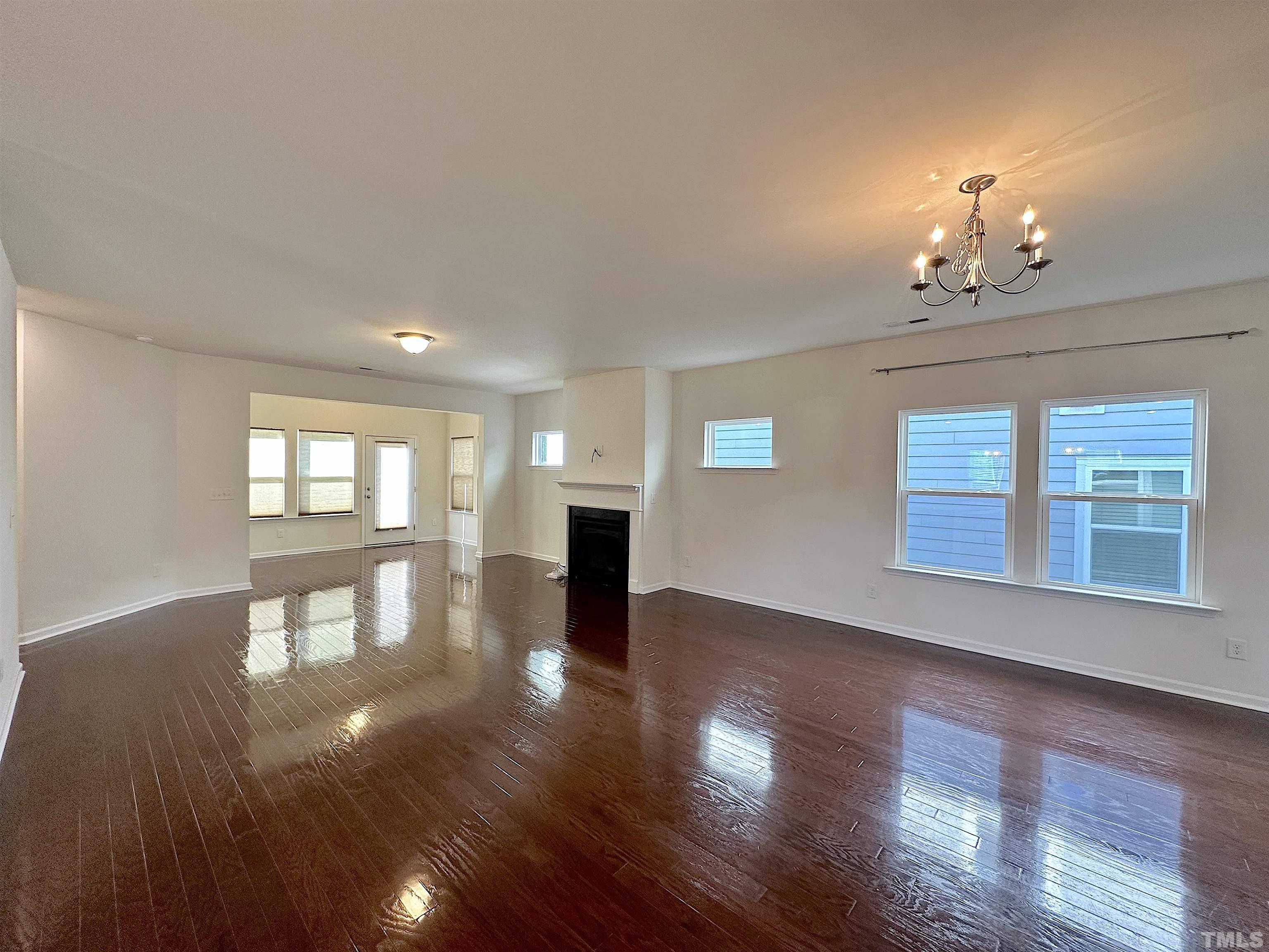 205 Azalea View Way Holly Springs, NC 27540 - Photo 3 of 29 a view of an empty room with wooden floor and a window