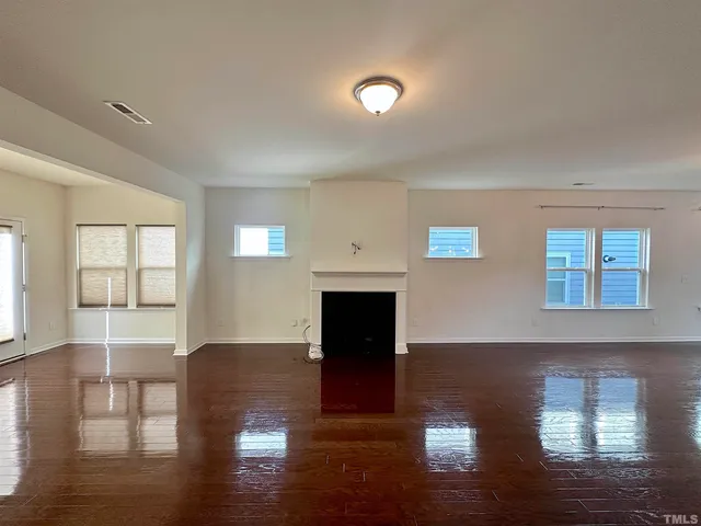 a living room with hard wood floors and a fireplace
