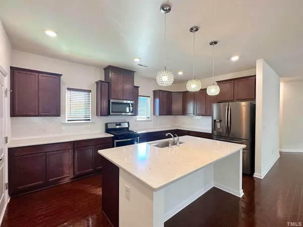 a kitchen with a stove a refrigerator and a sink
