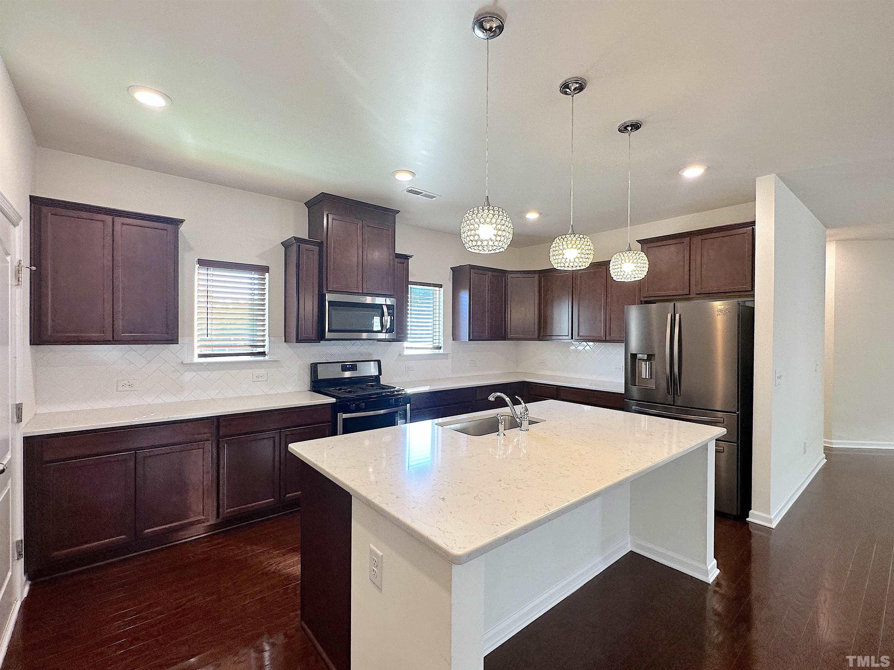 205 Azalea View Way Holly Springs, NC 27540 - Photo 8 of 29 a kitchen with a stove a refrigerator and a sink