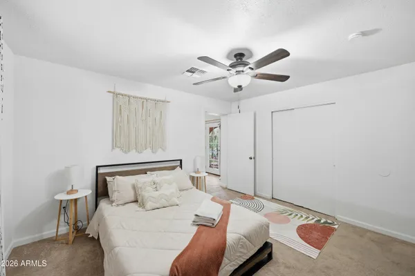 a bedroom with a bed a couch and a chandelier