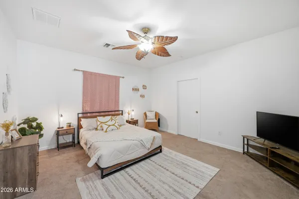 a bedroom with a bed and ceiling fan