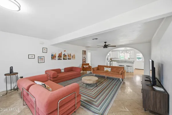 a living room with furniture a flat screen tv and a window