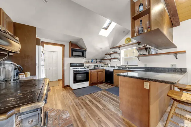 a kitchen with stainless steel appliances granite countertop a sink a stove and a refrigerator