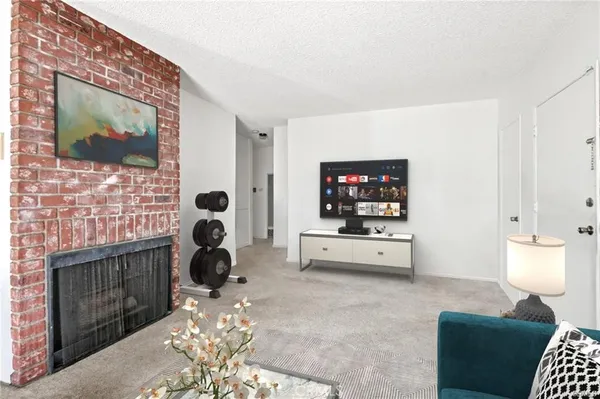 a living room with furniture a flat screen tv and a fireplace