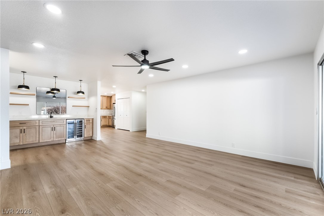 429 Crestway Road Henderson, NV 89015 - Photo 15 of 56 An inviting open-concept living space features a stylish wet bar, modern lighting, and durable plank flooring.