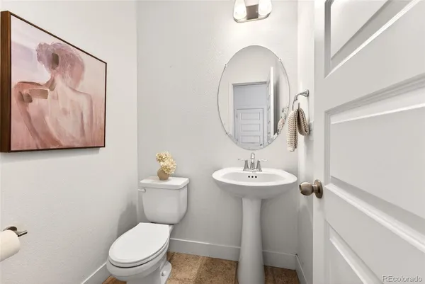 a bathroom with a toilet a sink and mirror