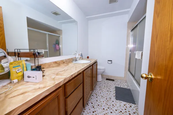 a bathroom with a double vanity sink mirror and shower