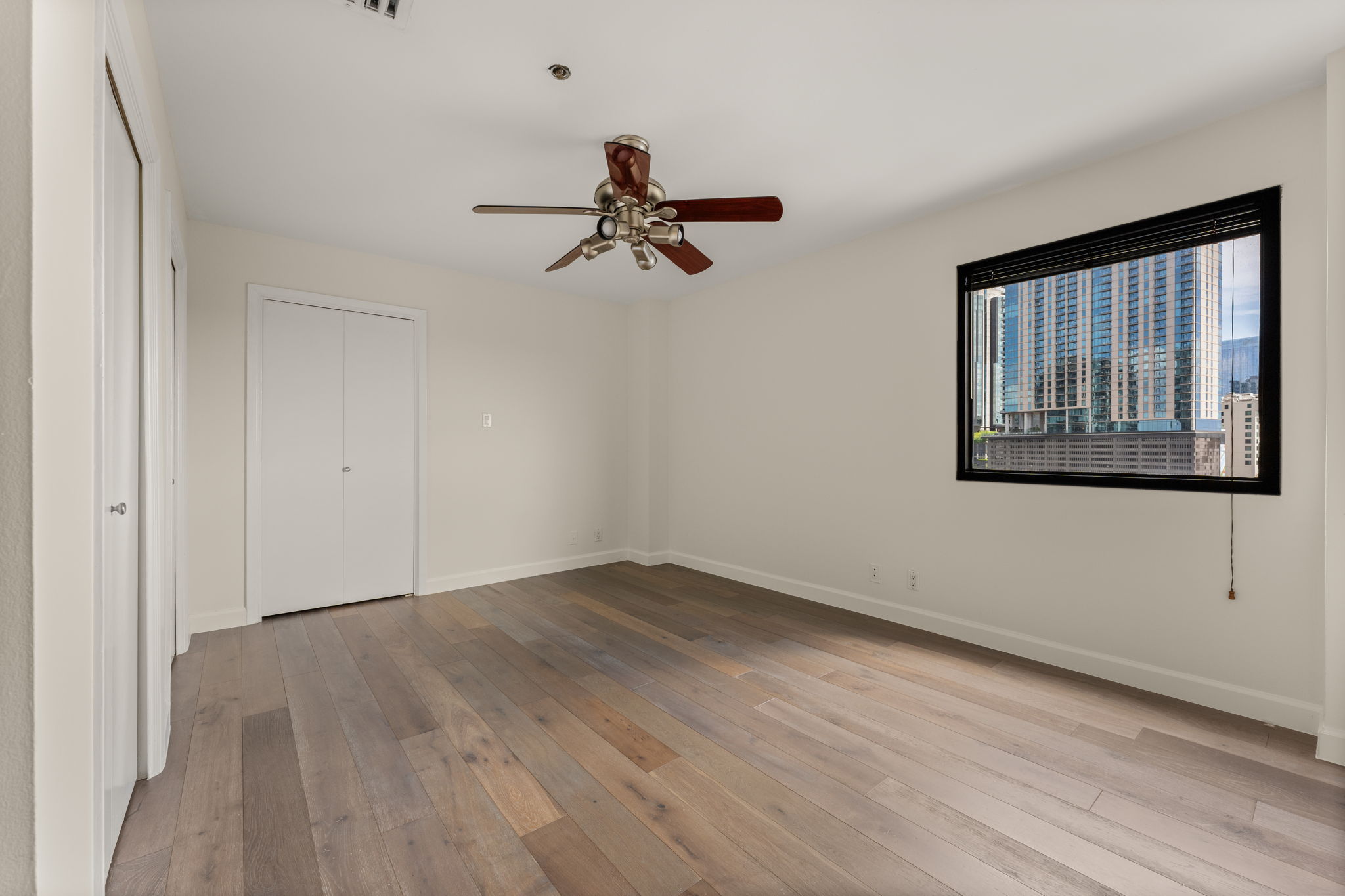 40 North Interstate Highway 35, Unit 11B2 Austin, TX 78701 - Photo 17 of 28 City views from a light-filled bedroom with rich hardwood floors.