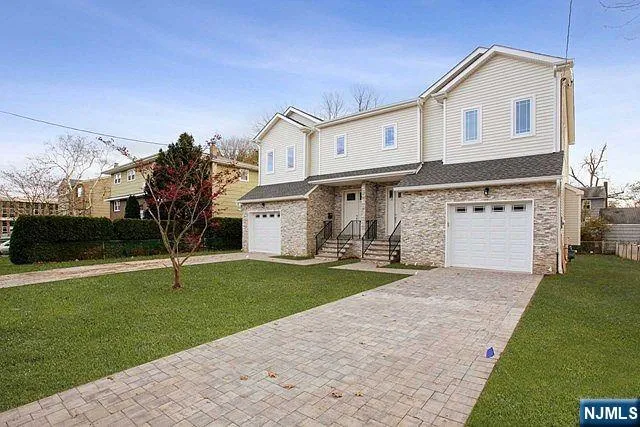 a front view of a house with a yard and garage