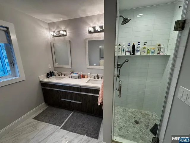 a bathroom with a sink shower and a mirror