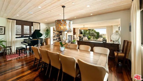 a kitchen with stainless steel appliances granite countertop a stove top oven a sink and a refrigerator with wooden floor