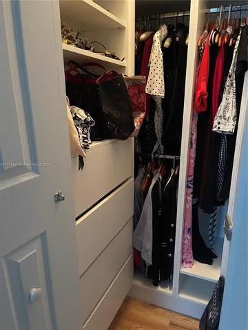 a view of walk in closet with clothes and shoes