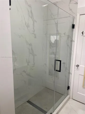 a bathroom with a glass shower door