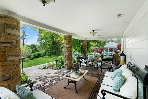 a living room with patio furniture and a garden