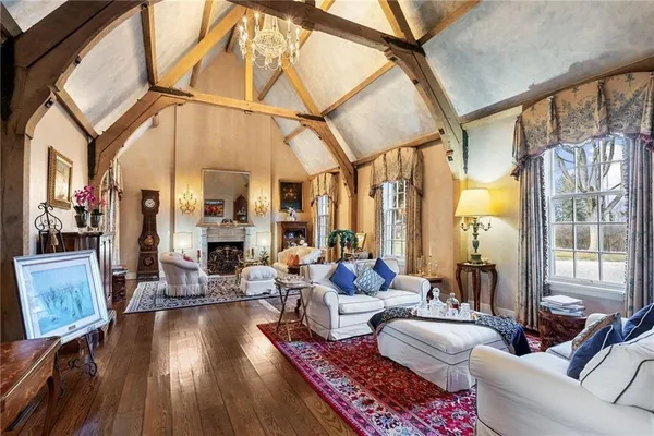 a living room with furniture a large window and wooden floor