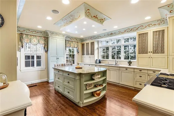 a kitchen with a stove a sink dishwasher and a dining table with wooden floor
