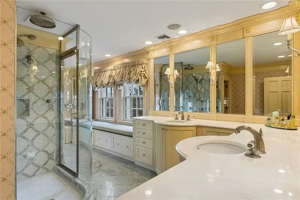 a bathroom with a tub a sink and glass windows