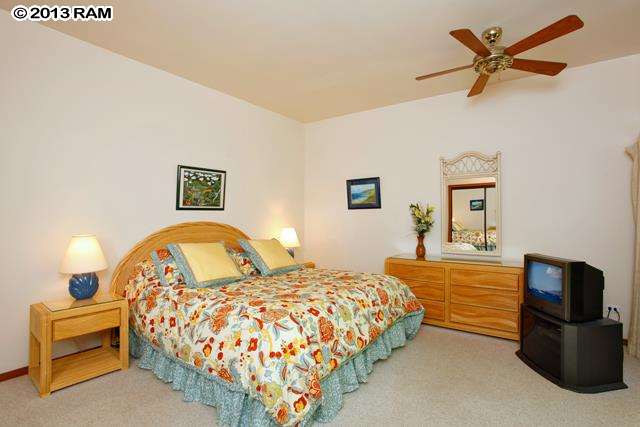 100 Ridge Road, Unit 2914 Lahaina, HI 96761 - Photo 12 of 24 a bedroom with a bed and a chandelier