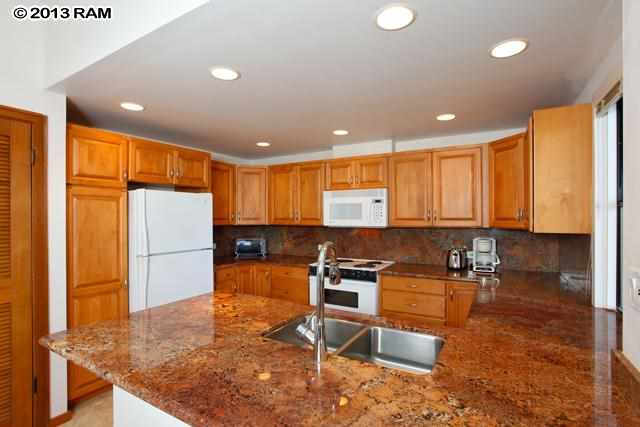 100 Ridge Road, Unit 2914 Lahaina, HI 96761 - Photo 5 of 24 a kitchen with stainless steel appliances granite countertop a stove a sink and a refrigerator