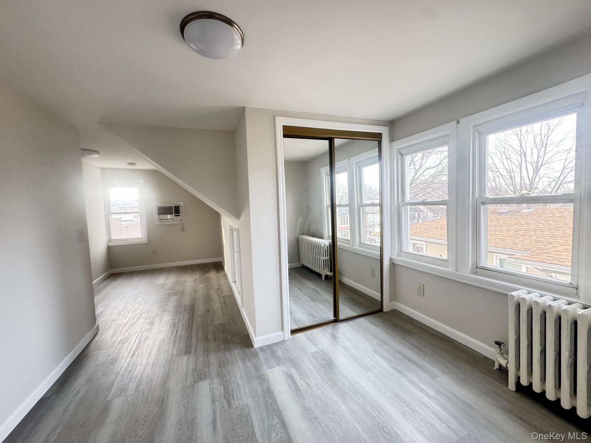 164-36 77th Road Queens, NY 11366 - Photo 13 of 20 wooden floor in an empty room with a window