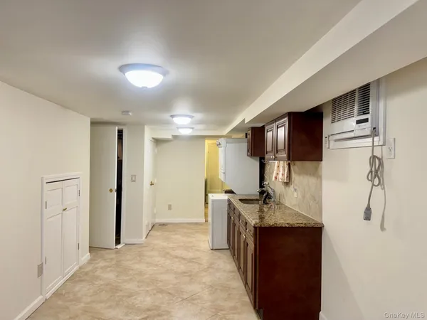 a bathroom with a granite countertop sink a mirror and shower